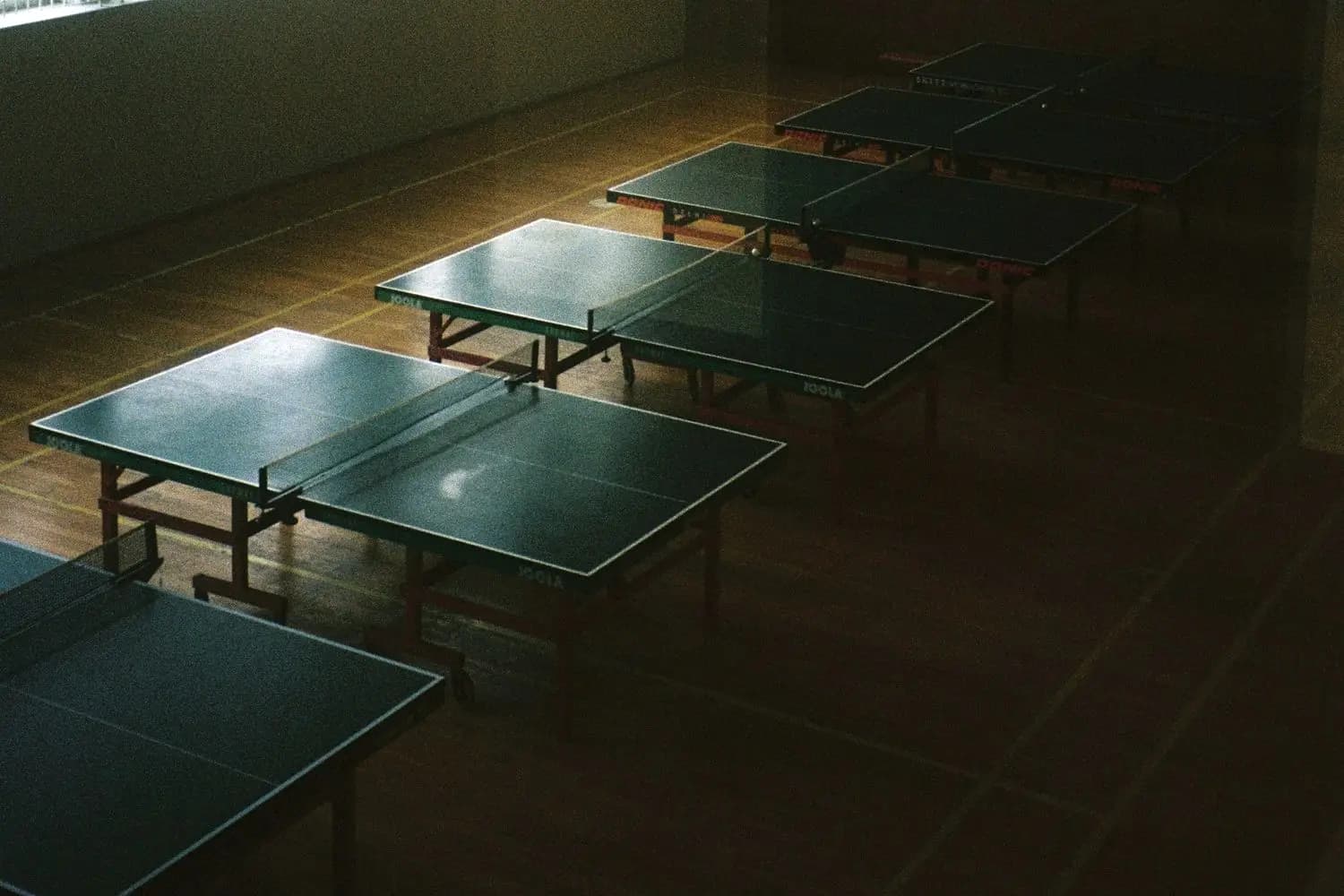 Several table tennis tables in a sports hall